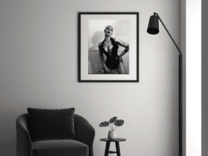 Black and white fine art print of Madam Sophie in LA, confidently posed in a sleek black corset, accentuated by deep shadows and dramatic lighting.