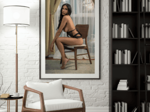 An elegant 20x30 art nude photograph of a model seated on a wooden chair, wearing delicate black lingerie. The soft natural light streaming through the sheer curtains highlights her confident pose, creating a striking balance of sensuality and sophistication. Perfect for art collectors and admirers of fine photography. **Frame Not Included**