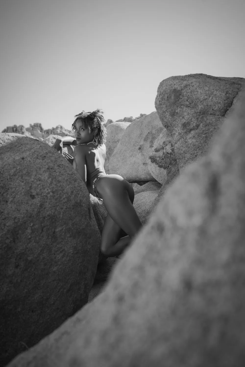 Silent Monument black and white desert fine art nude photography print featuring Divine standing between rocks in Joshua Tree
